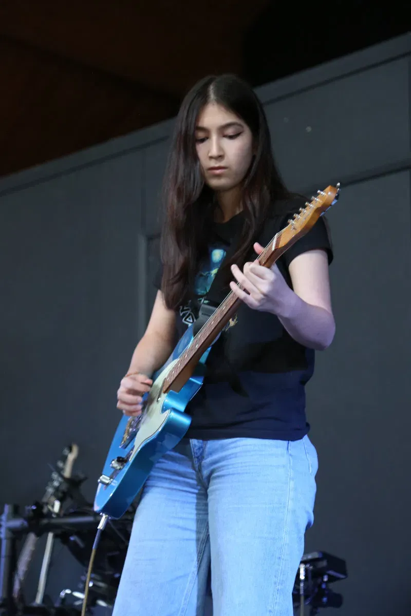 DeRosa pupil performing electric guitar live on stage