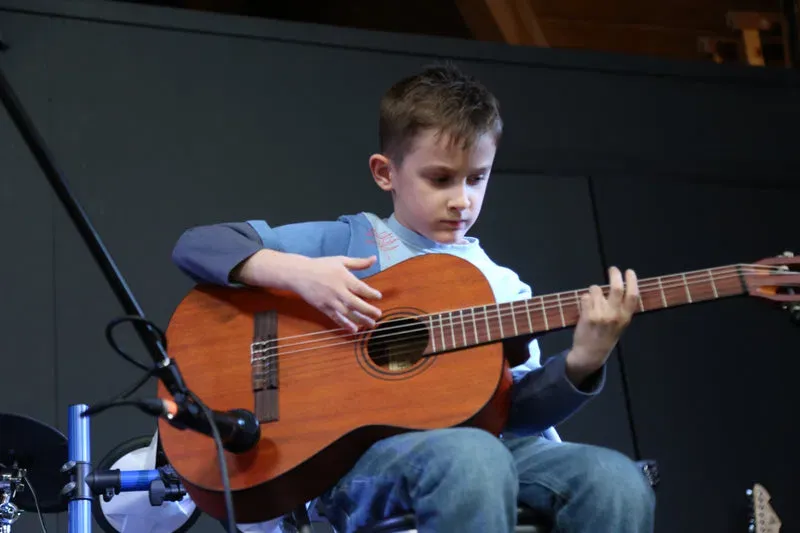 DeRosa Music pupil performing on acoustic guitar
